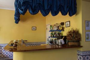 a kitchen with a bar with a blue curtain at Hotel Sintra Jardim in Sintra
