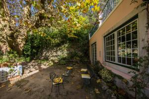 a patio with a table and chairs next to a building at Hotel Sintra Jardim in Sintra