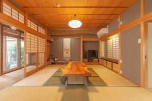 a living room with a table in the middle of it at 庭之宿 新大阪日本庭園の家 -Residence inn Niwanoyado- in Osaka