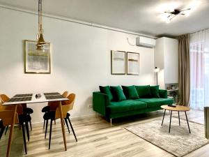 a living room with a green couch and a table at Sunset View Apartment in Timişoara