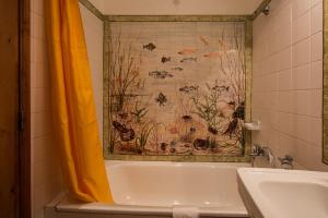 a bathroom with a shower curtain and a sink at Hotel Sintra Jardim in Sintra