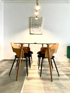 een eettafel met stoelen en een foto aan de muur bij Sunset View Apartment in Timişoara