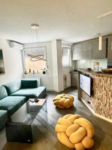 ein Wohnzimmer mit einem blauen Sofa und einer Küche in der Unterkunft Apartment next to the Wilson's Promenade in Sarajevo