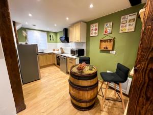 une cuisine avec un tonneau à vin, une table et des chaises dans l'établissement Au Duplex de Jeannala, à Sélestat