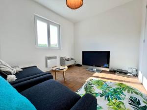 a living room with a blue couch and a flat screen tv at COC - L'Idéal in Hervelinghen