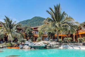 um resort com palmeiras e uma piscina em Rocks Beach Boutique em Phu Quoc