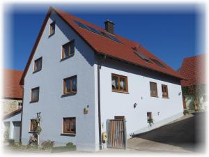 una gran casa blanca con techo rojo en Ferienwohnung Pfrang en Michelau