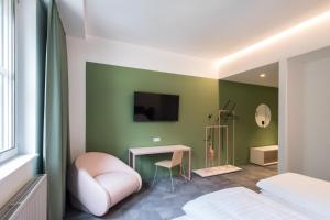 um quarto com uma cama, uma mesa e uma televisão em Airbase Hotel em Kalsdorf bei Graz