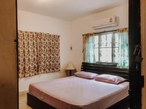 Cama en habitación con ventana y cama sidx sidx sidx sidx en Green Garden, en Bangrak Beach