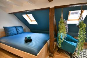 un lit dans une chambre avec un mur bleu dans l'établissement Au Duplex de Jeannala, à Sélestat