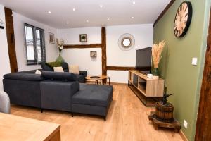 un salon avec un canapé et une télévision dans l'établissement Au Duplex de Jeannala, à Sélestat
