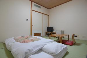 a bedroom with a bed with a table and a desk at Hotel Sunroute Aomori in Aomori