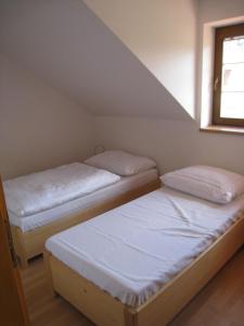 2 camas individuales en una habitación con ventana en Skalský Mlýn en Lísek