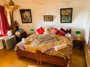 ein Schlafzimmer mit einem großen Bett mit bunten Kissen in der Unterkunft Hotel Victoria in Jaisalmer