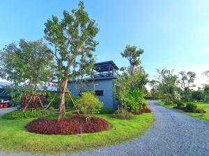een huis met een boom aan de kant van een weg bij ปีกุนรีสอร์ท & Swimming pool (Pigoon Resort) 