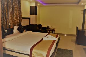 a hotel room with a bed with a towel on it at Hotel Vaishnavi Heights in Aurangābād