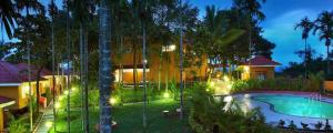 a resort with a swimming pool and a building at Karapuzha Village Resort in Wayanad