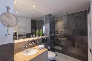 a bathroom with a sink and a shower and a toilet at Ravensberger Hof in Bielefeld