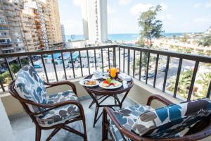 a balcony with a table with a plate of food on it at AIFU Hotel El Montazah Alexandria in Alexandria