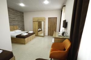 una camera con un letto e una sedia di ANGINE Resort Hotel a Vanadzor Altre 37 foto