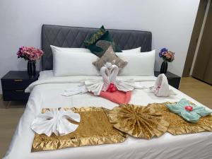 Eaton Residences KLCC by Luna في كوالالمبور: سرير عليه مجموعه من الملابس
