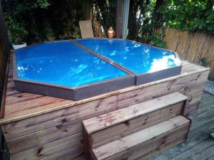 a hot tub sitting on top of a wooden deck at Chalet avec spa à Libourne proche St-Emilion in Libourne
