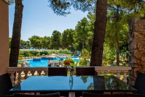 a table on a balcony with a view of a pool at Matilde Beach Resort in Vodice