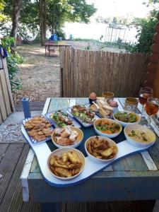 une table avec de nombreuses assiettes de nourriture dans l'établissement Chalet avec spa à Libourne proche St-Emilion, à Libourne