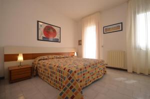 una camera d'albergo con letto e finestra di Villaggio Dei Fiori a Bibione