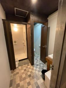 ein Bad mit einer ebenerdigen Dusche und einer Glastür in der Unterkunft IslandHonu in Ishigaki-jima
