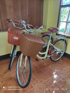 Duas bicicletas com cestas estão estacionadas num quarto em Chanmuang guesthouse em Mae Hong Son