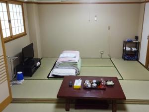 una camera con un tavolo e un letto in esso di Imazato Ryokan ad Osaka