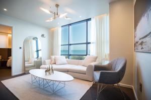 a living room with a couch and two chairs and a table at UH SUITE THE HAEUNDAE in Busan
