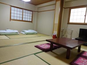 a room with a table and a room with a bed at Imazato Ryokan in Osaka