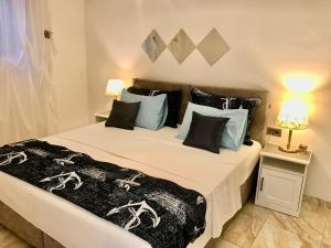 a bedroom with a large white bed with blue pillows at Charming view old town ap, with free parking in Dubrovnik