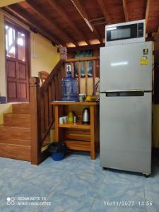 a kitchen with a white refrigerator and a staircase at Chanmuang guesthouse in Mae Hong Son
