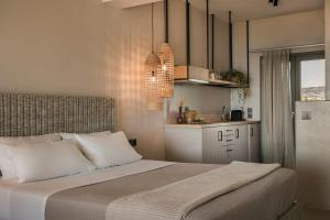 a bedroom with a large bed and a kitchen at Thalassa Suite-Grand Blue Beach residence in Lixouri