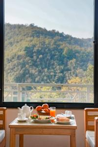 a table with food and a view of a mountain at Trekkers Inn Boutique Hotel Pokhara in Pokhara