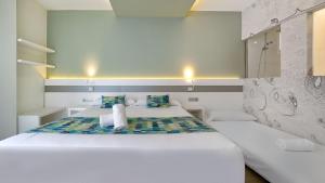 Un dormitorio con una cama blanca con toallas. en Hotel Aloe Canteras, en Las Palmas de Gran Canaria 37 fotos más