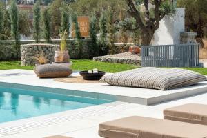 a pool with a bed and cushions next to a pool at Casa di Maria in Afantou
