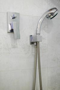 a shower with a shower head in a bathroom at Beach House Apartment, Playa Malagueta in Málaga