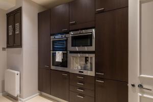 a kitchen with brown cabinets and two ovens at PickThePlace 3-bedroom Portman square in London