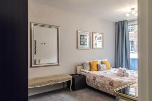 a bedroom with a bed and a mirror and a window at PickThePlace 3-bedroom Portman square in London