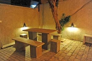 two benches and a table in a room with a tree at The Villa In Lavinia in Mount Lavinia