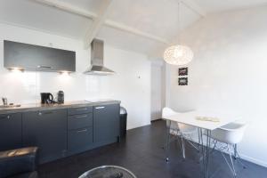 eine Küche mit blauen Schränken und einem weißen Tisch in der Unterkunft Hello Zeeland - Vakantiehuis Beatrixstraat 29A in Domburg