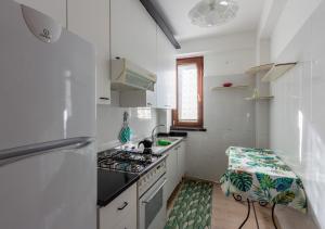 a white kitchen with a stove and a sink at Casa Sofia - Irpinia in Avellino