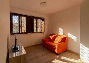 a living room with an orange couch and a desk at Casa Sofia - Irpinia in Avellino