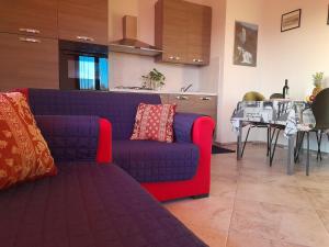 een woonkamer met een paarse bank en een tafel bij Appartamento Sofia - Nord Sardegna - Badesi in Badesi