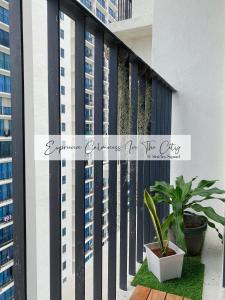 una pianta in una pentola su un balcone con edifici di 6Pax Suites Setia City Convention Trefoil Shah Alam SiS Homestay a Shah Alam