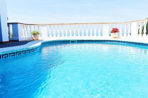 una piscina de agua azul en una casa en VILLA MARIA vistas al mar y piscina privada, en Son Bou